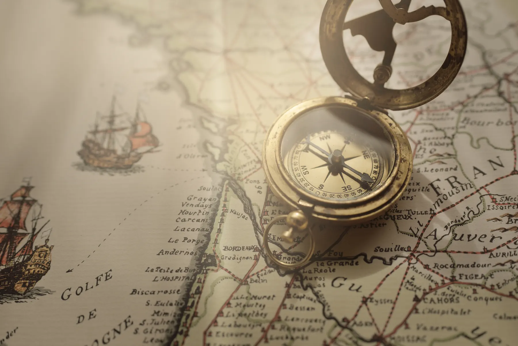 An antique compass resting on a nautical chart